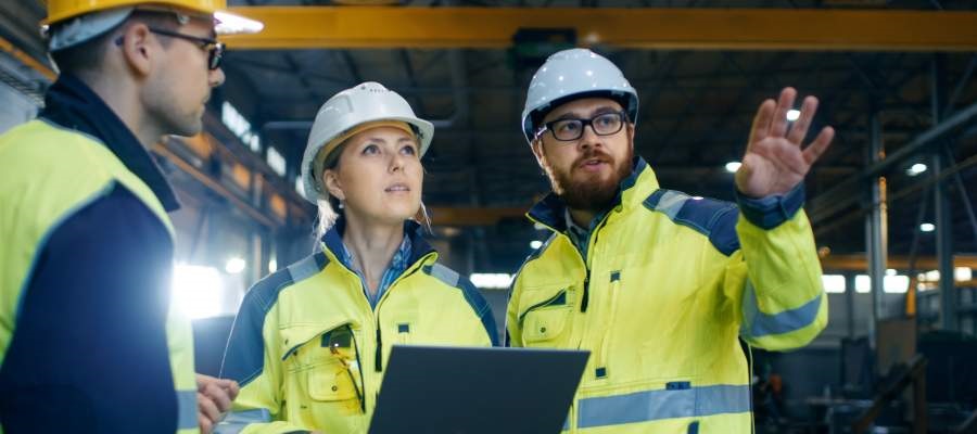 explanation, workplace communication, workers talking, plans, documents, working clothing, hard hat, smiling, workers, safety culture, safe working environment, factory hall, culture change, organisational change, sustainable safety culture, culture change across sites, human factors, SafeStart, SafeStart International, safety habits, workplace safety, occupational safety, improve safety culture, boost safety awareness, reduce human failure, reduce injuries, injury reduction, reduce accident rates, improve company figures, prevent critical errors, implement a positive culture change at your company, promote employee engagement, boost employee commitment, 24/7 safety, safety round the clock, being safe 24/7, safe behavioural patterns, learn safe behaviour, acquire universal safety skills, safety skill for families, safety skills for children, safety skills for everyone, safety training for employees, safety for the whole company, safety training for kids, improve operational efficiency, improve quality, safety-related habits, safety-related behaviour, risk patterns, ensure high performance, critical states, critical decisions, critical errors, how injuries occur, how to prevent injuries, how to prevent accidents